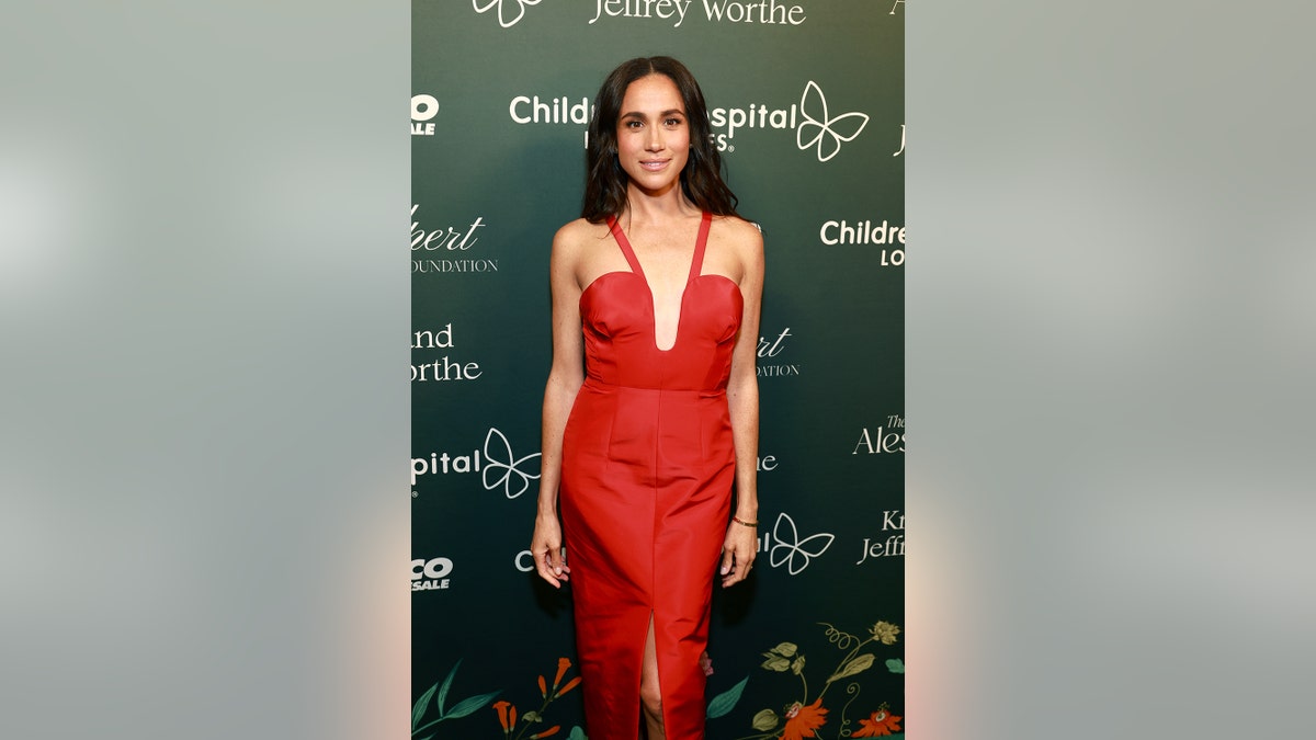 Meghan Markle posing in a glamorous red dress.