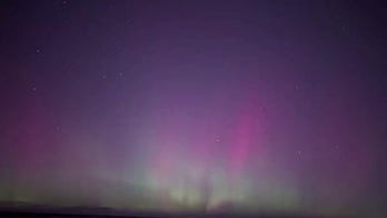 Aurora lights up night sky over Lake Michigan