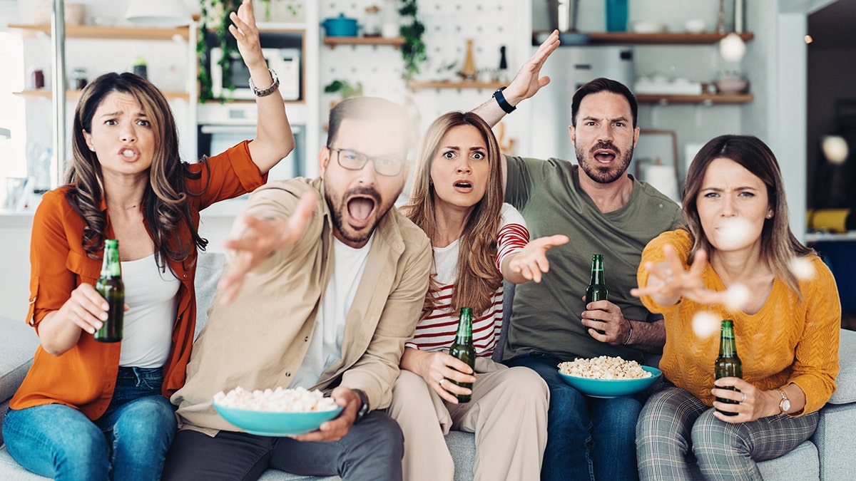 Group of friends gathered at home to watch TV and eat snacks